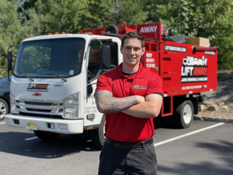 A Lift Away Junk Removal expert posing with a junk removal truck