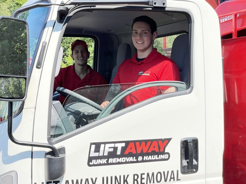 Lift Away pros posing in a junk truck